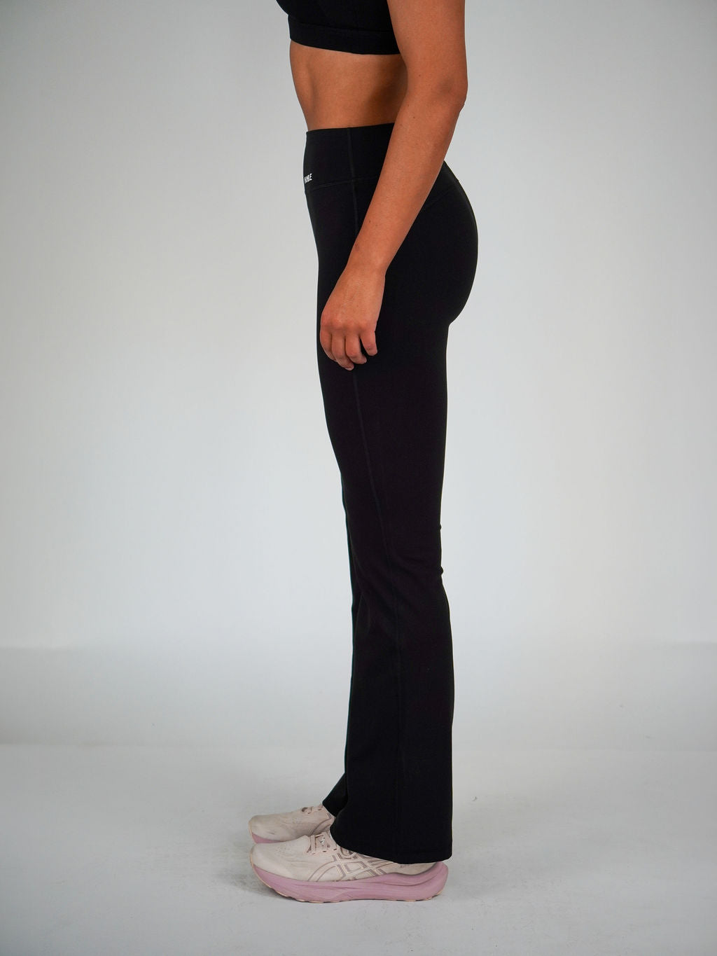 Kvinna i svarta Solid Flare Tights från Humble Athletics