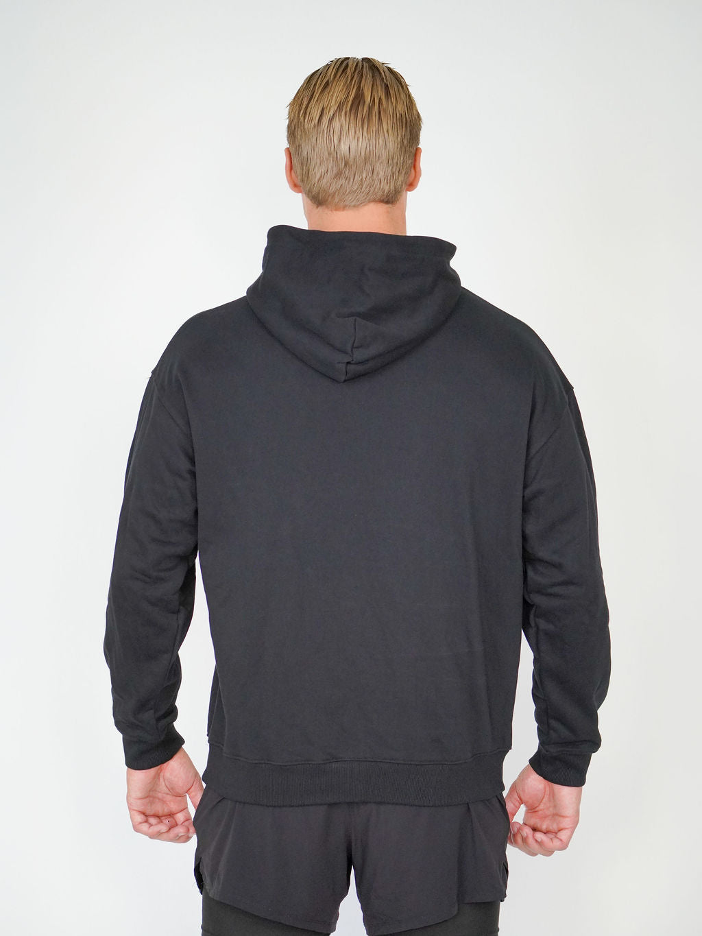Man i svart Solid Hoodie från Humble Athletics, mjuk fleece